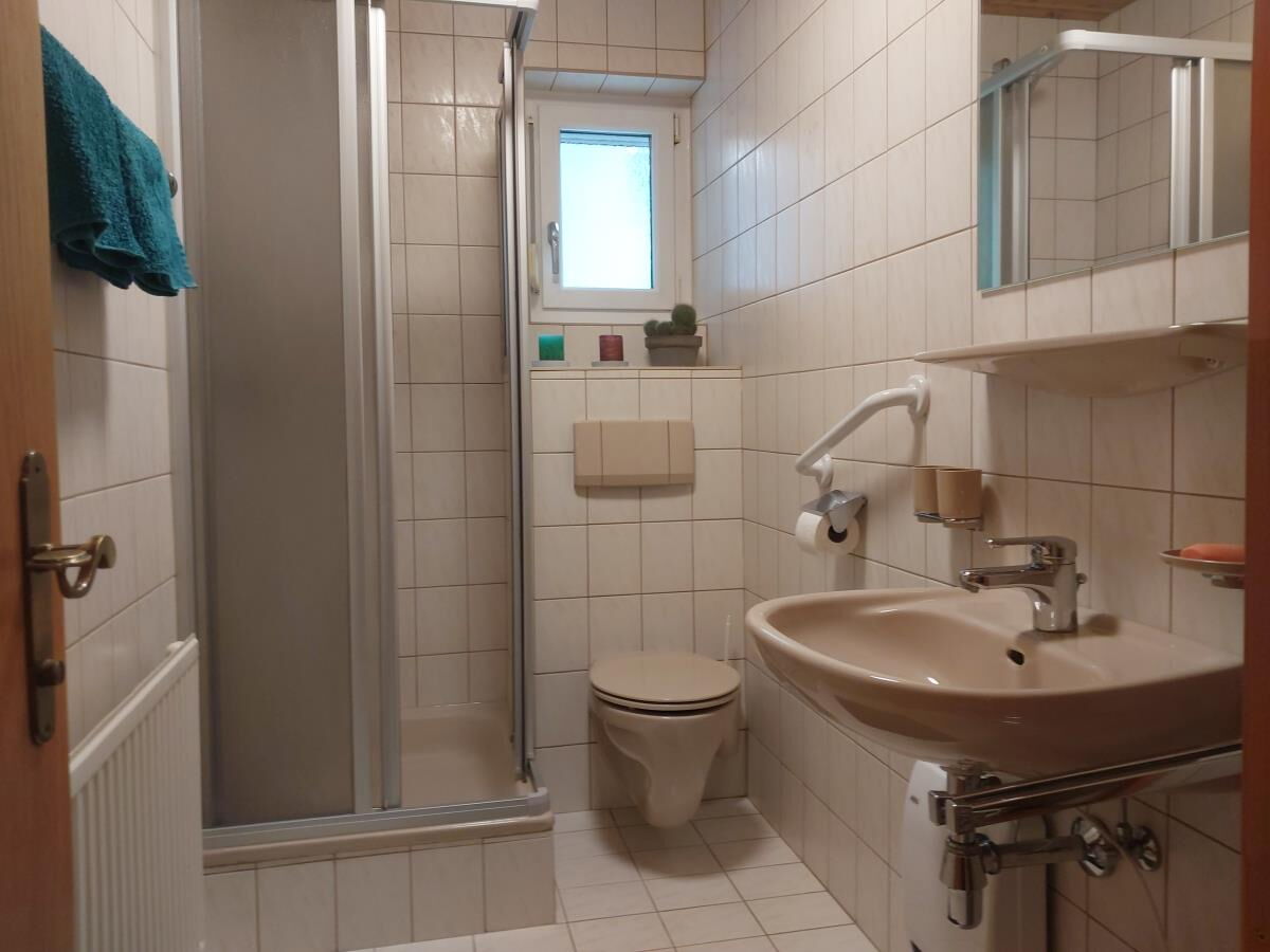 Modernes Badezimmer der Ferienwohnung Sonnseitn Karwendel mit Dusche, WC, Waschbecken und Fenster