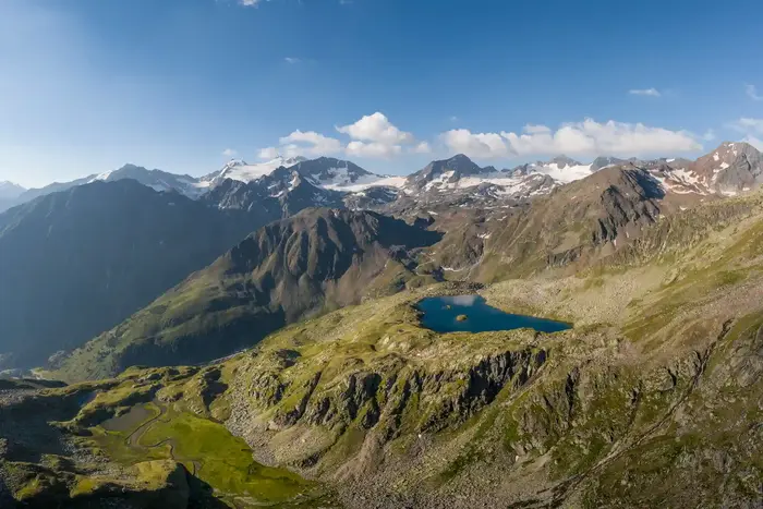 A turquoise mountain lake on the plateau above the Stubai Valley, rock ridges all around