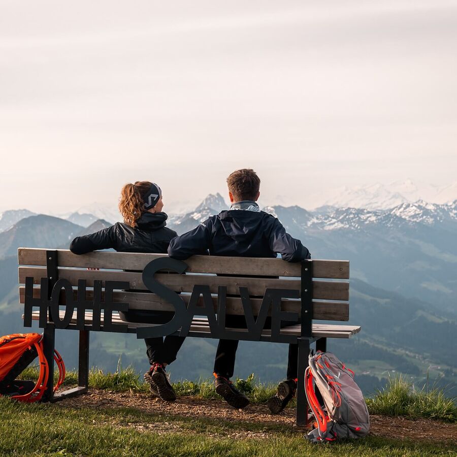 Auf einer Bank zu zweit den Ausblick von der Hohen Salve genießen.