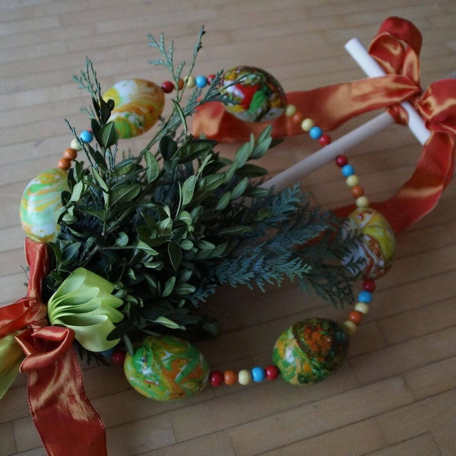 Ein schöner Palmbuschen mit Eier rund herum und einer orangen Schlaufe abgerundet.