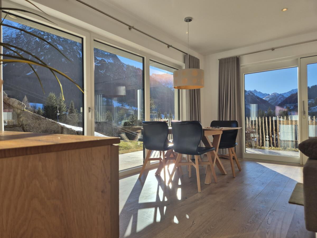 Offener Wohn- und Essbereich mit Küchentheke und Blick zur Sonnenterrasse in der Garten-Luxuslodge Hammerspitze, Luxuslodge für 6 Personen im Kleinwalsertal