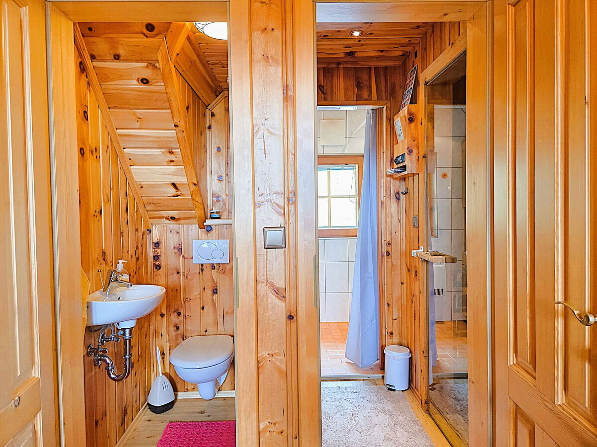 Separates WC mit Waschbecken und Holzverkleidung im Gang der Pietschacher Almhütte