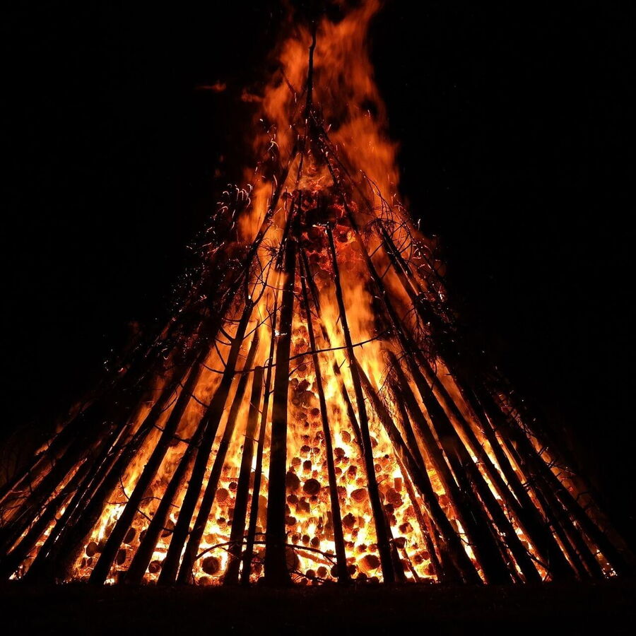 Ein großes Sonnwendfeuer wird in den Bergen entzündet.