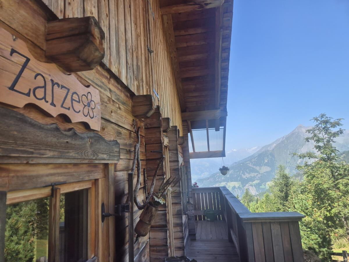Holzfassade der Zarze Almhütte mit geschnitztem Namensschild und Blick ins Tal, Alleinlage auf 1.880 m in Osttirol