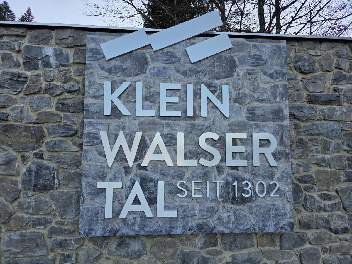 Stone plaque reading Kleinwalsertal seit 1302 at the entrance to the valley, holiday region of the Sonnenbalkon luxury lodge Bärenkopf in Mittelberg