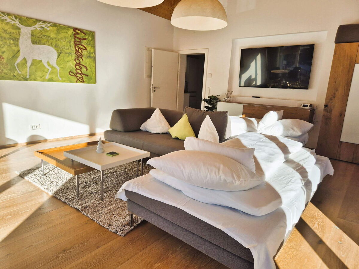 Living area with corner sofa and sofa bed in the open loft of the Panorama luxury lodge Ifen, holiday apartment for four people in the Kleinwalsertal