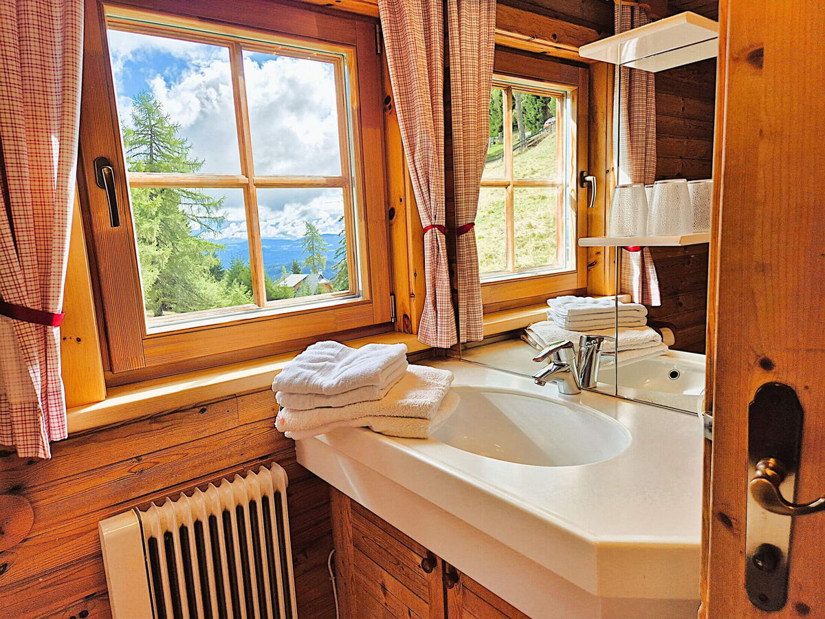 Waschbecken unter dem Fenster im Badezimmer der Pietschacher Almhütte mit Blick auf die Nockberge