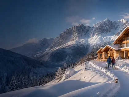Verschneite Hütte mit Licht im Fenster – Schneehütte mieten