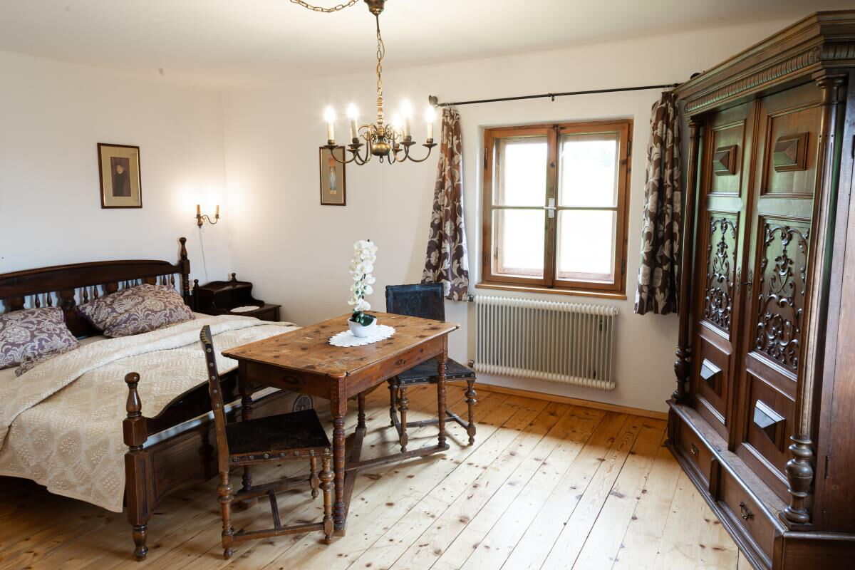 Bedroom in the Grafenhäusl with bed, desk and an old farmhouse wardrobe, holiday house with 4 bedrooms in Tyrol