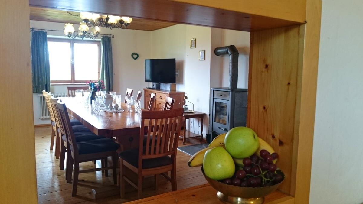 Dining room in the Grafenhäusl with the table laid and the stove, holiday house for families and friends in Tyrol