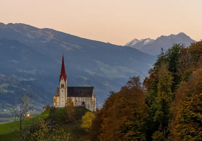 Church on the Pankrazberg above the Fügenberg in front of the Zillertal mountains in autumn