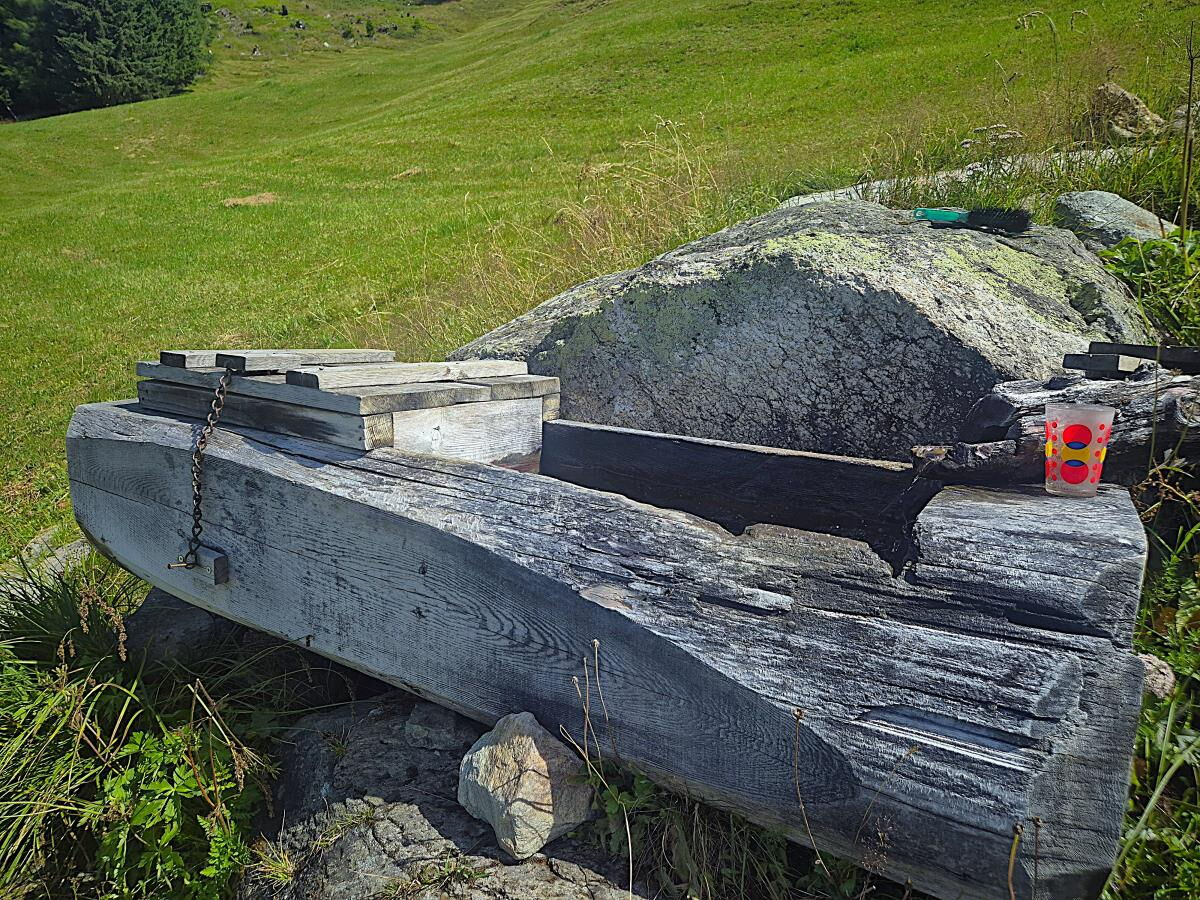 Alter Holztrog mit Bank vor der Zarze Almhütte, originale Almgeräte auf 1.880 m in Osttirol