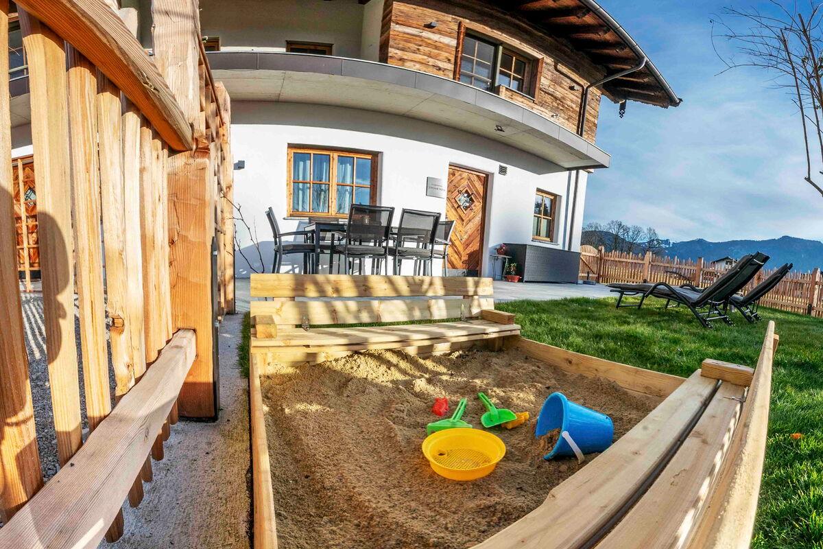 Sandkiste und Terrasse vor dem Zuahaus am Riedhof, Bauernhofurlaub mit Kindern in Tirol