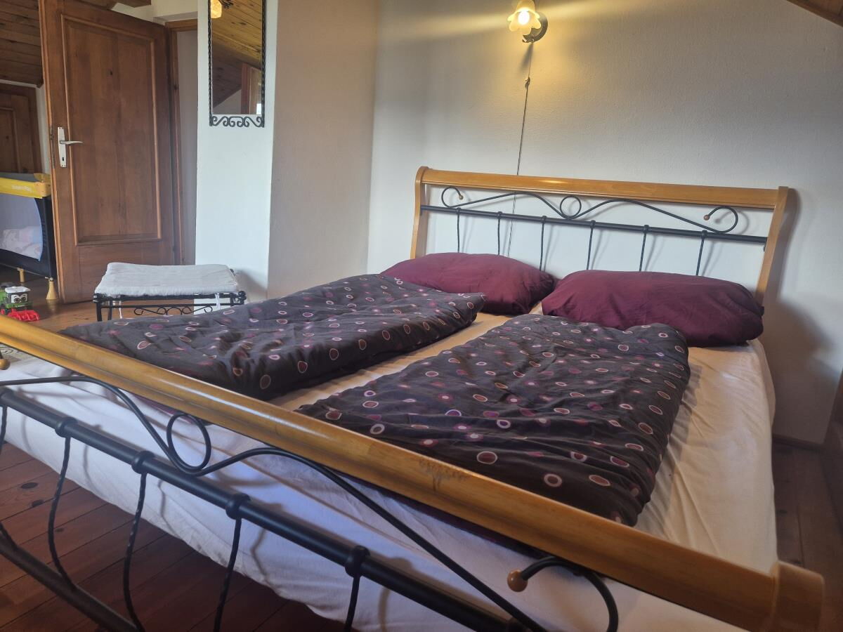 Bedroom in the Grafenhäusl with a metal bed and dark linen, holiday house with four bedrooms in Tyrol