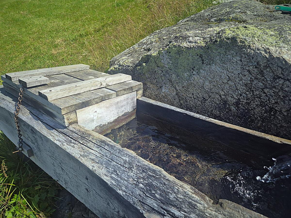 Brunnentrog aus Holz mit Quellwasser an der Zarze Almhütte, Quellwasser-Kühlung im Nationalpark Hohe Tauern
