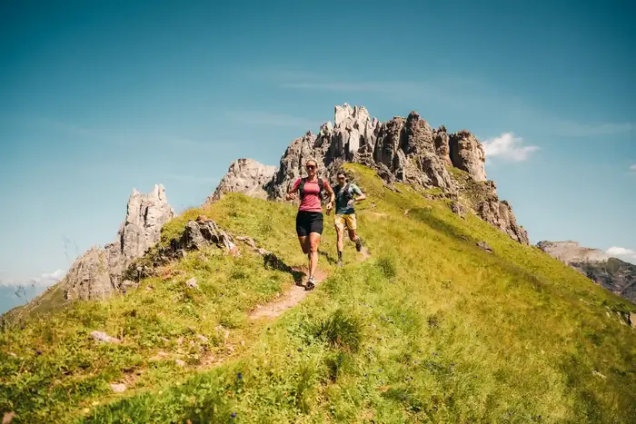 Hikers on the narrow ridge below the rocky spires of the Elfer near Neustift