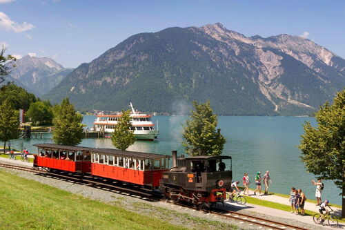 Die Achenseebahn und im Hintergrund der kristallklare Achensee und der Dampfer.