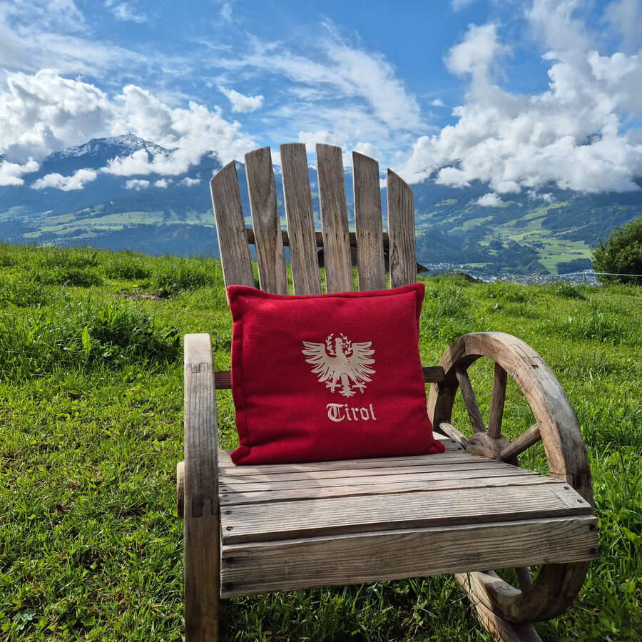 Schaukelstuhl aus Holz und im Hintergrund die Bergkulisse.