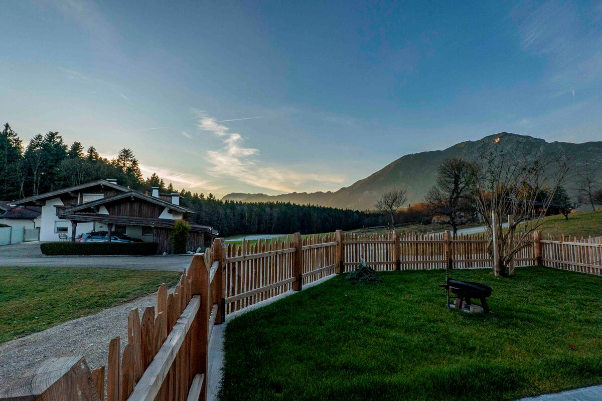Garten am Riedhof mit Zaun und Feuerschale im Abendlicht, Ferienwohnung am Bauernhof in Tirol