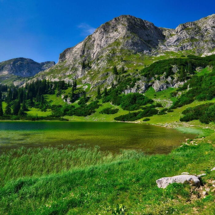 Mit glasklarem Wasser und im Hintergrund die hohen Berge ist dies ein schöner Kraftplatz.