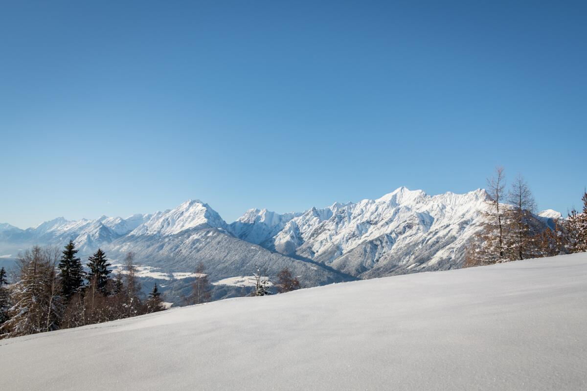 Unberührte verschneite Wiese am Kolsassberg mit Blick auf die Karwendelkette, Winterlandschaft an der Ferienwohnung Sternenhimmel