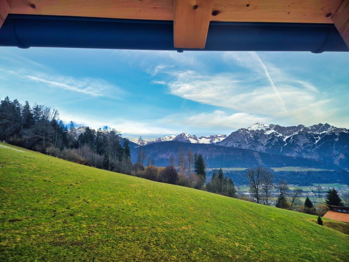 Blick aus dem Fenster der Ferienwohnung Sternenhimmel über die grüne Wiese ins Inntal und auf die Berge am Kolsassberg