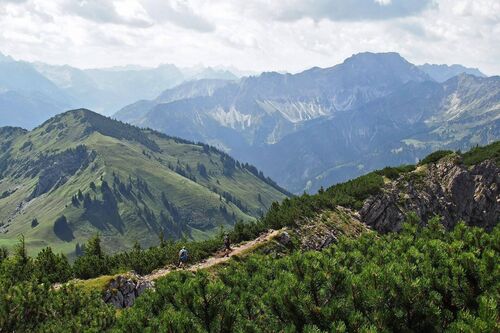 Einen schmäleren Wanderpfad über den Gebirgsgrad durchlaufen.