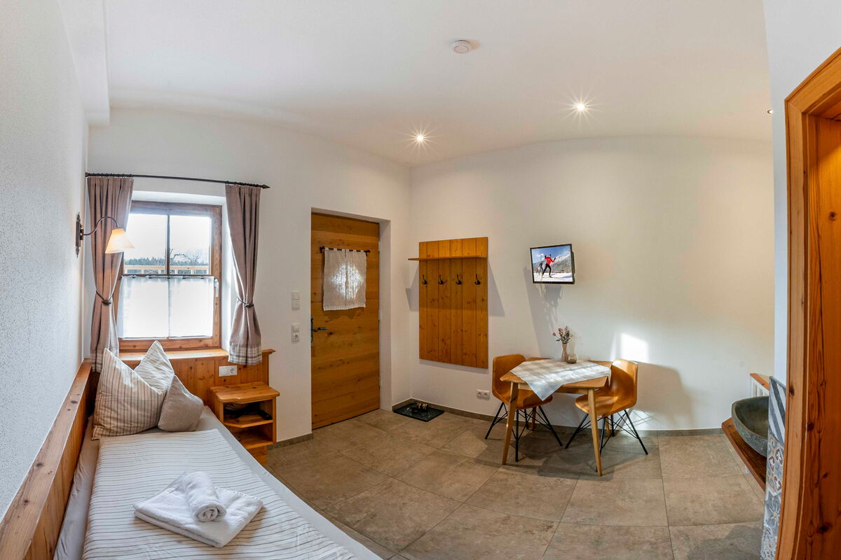 Wohnraum im Zuahaus mit Bett und Esstisch, Ferienwohnung für bis zu 5 Personen am Bauernhof in Tirol