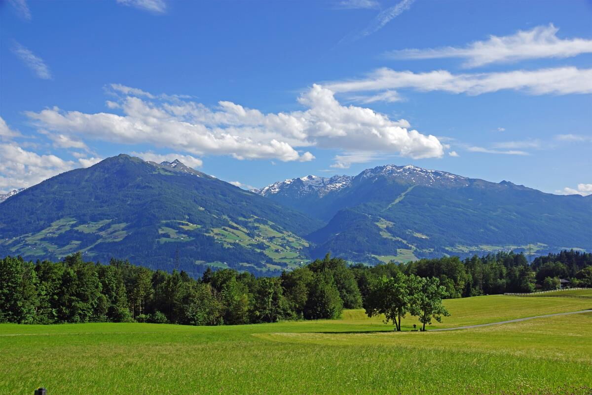 Weite grüne Wiese in Gnadenwald mit Blick über das Inntal auf die Berge, Umgebung der Pferdeheimat am Karwendel in Tirol