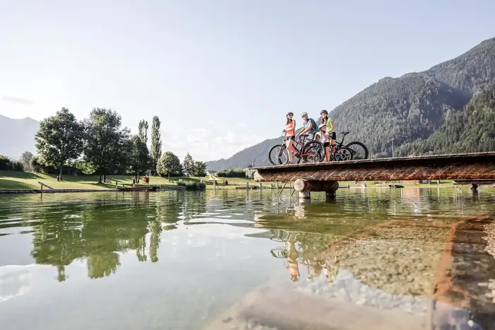 Bathing lake in Fügen-Kaltenbach with a wooden jetty and mountains in the background