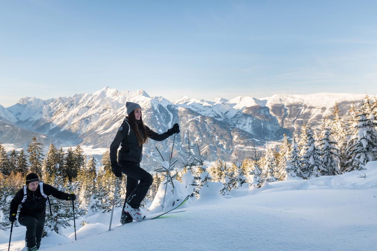 Ski tourers crossing the snowy meadow in front of the Karwendel range, winter sports around the Tiroler Hütte at 890 metres