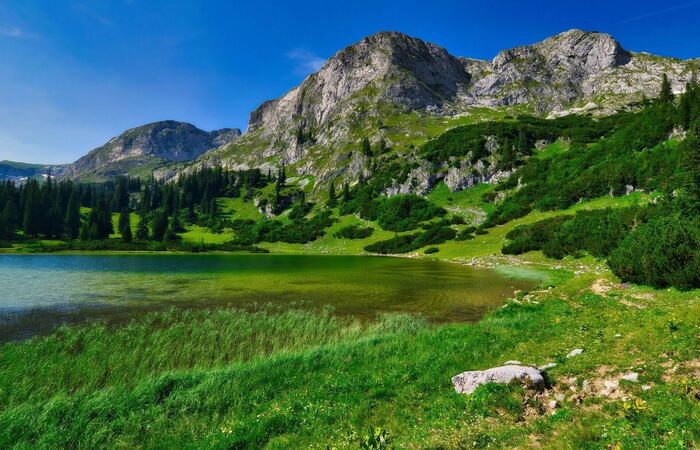 Clear mountain lake below rocky peaks