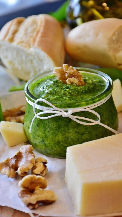 Bärlauch Pesto mit Nüssen und Käse serviert zu einem Weißbrot.