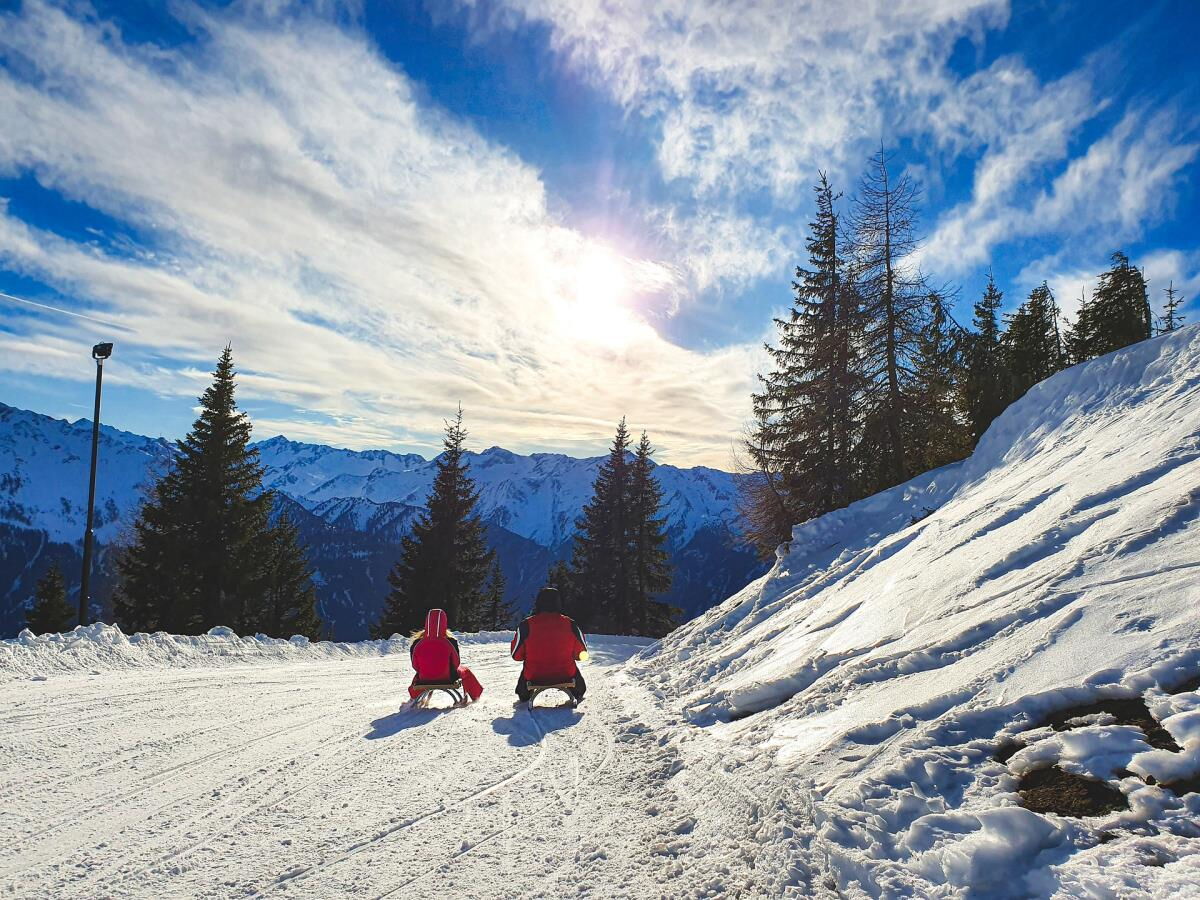 Tobogganing with panorama on the Gerlosstein run near the Breitbergalm, winter in the Zillertal
