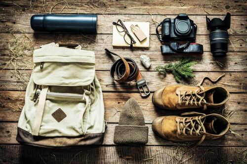 Für den Urlaub in den Bergen das wichtigste vorbereiten an Utensilien wie Rucksack, Thermosflasche, Wanderschuhe, Mütze, Kamera und noch mehr.