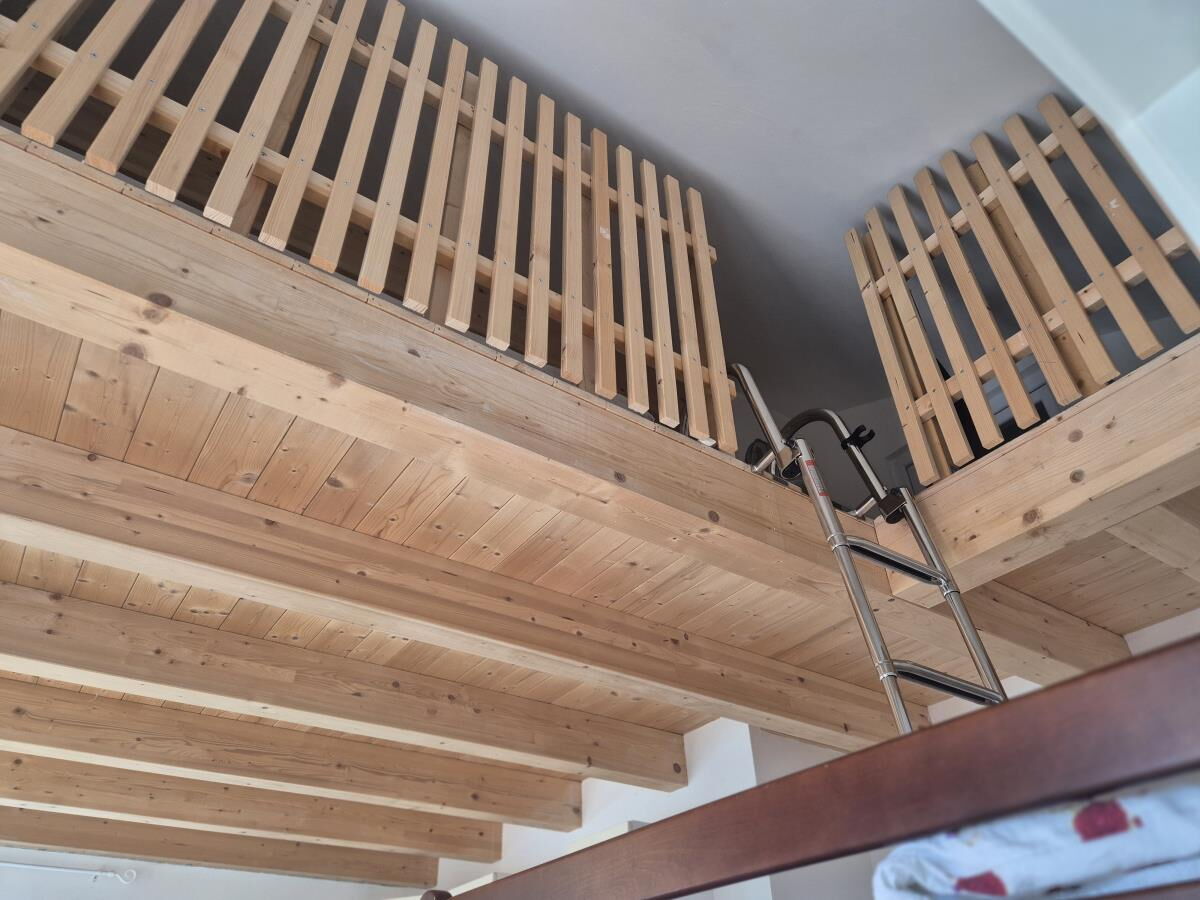 Holzleiter hinauf zur Schlafgalerie unter dem Dach der Ferienwohnung Sternenhimmel am Kolsassberg, zusätzliche Schlafplätze für Kinder