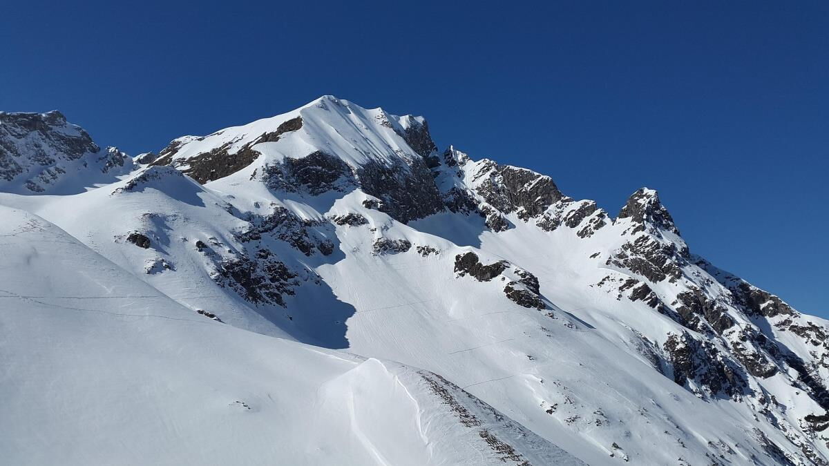 Snow-covered mountain ridge with rocky pinnacles and a single ascent track above the Kleinwalsertal, ski touring terrain near the Sonnenbalkon luxury lodge Bärenkopf