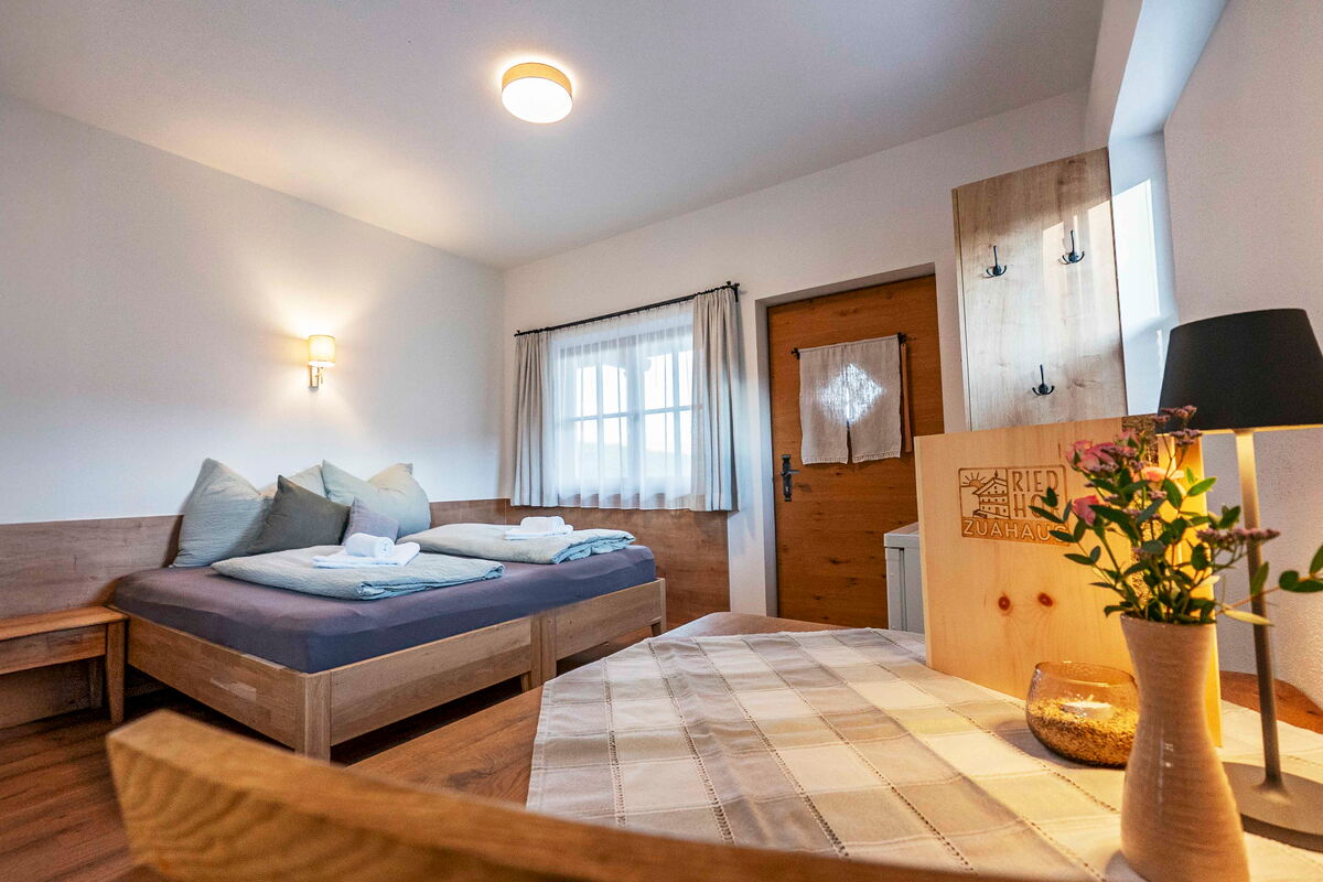 Offener Wohn- und Schlafraum mit Doppelbett, Tisch und Altholz in der Roggnkammer am Riedhof in Breitenbach, 20 Quadratmeter exklusiv für zwei