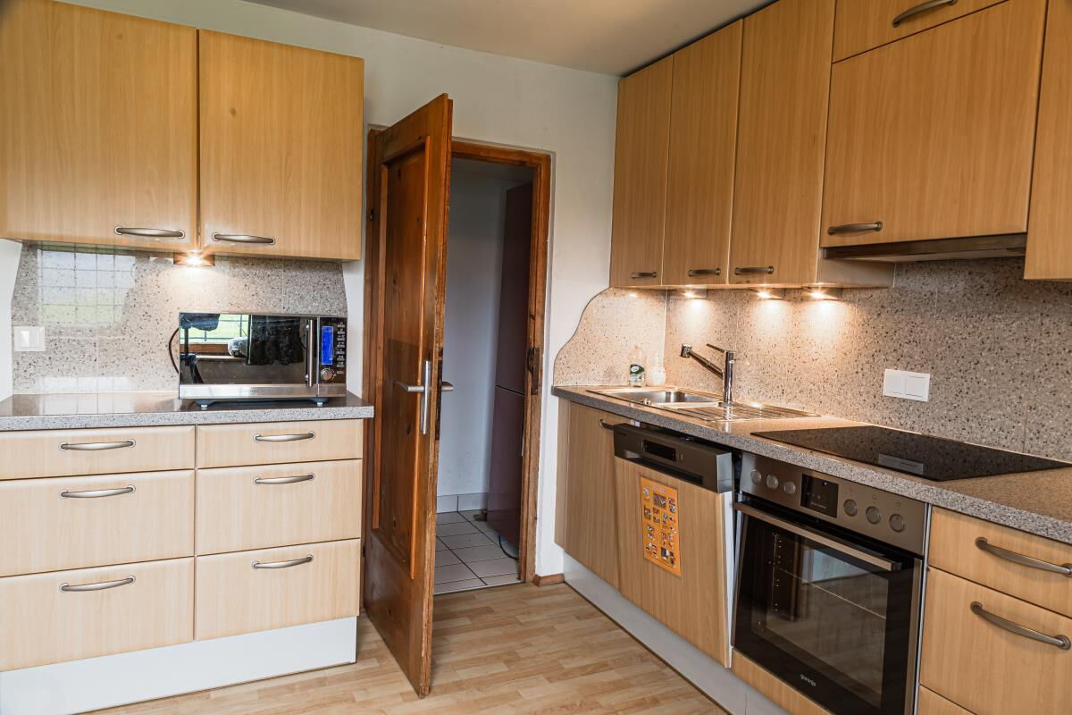 Kitchen in the Grafenhäusl with cooker, sink and microwave, self-catering holiday house for 12 people in Tyrol