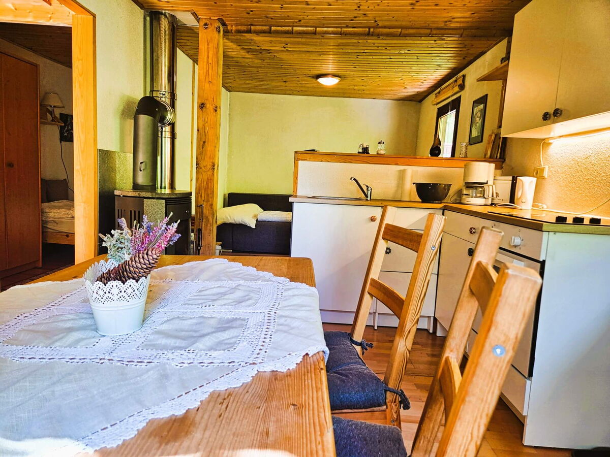 Gedeckter Esstisch mit Spitzendecke und Blumenstrauß vor der Küche im Kochhäusl am Wattenberg in den Tuxer Alpen