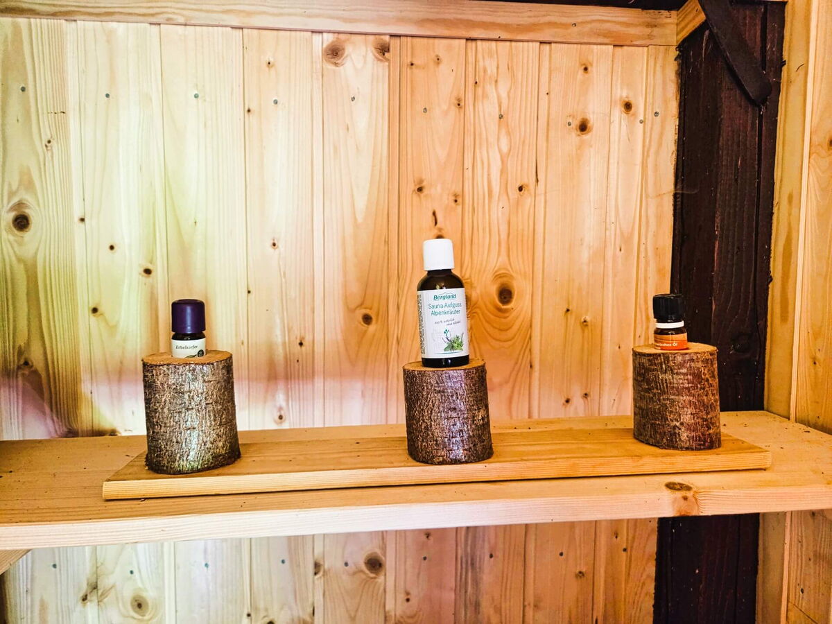 Aufgussmittel und Duftöle auf dem Holzregal der privaten Sauna im Kochhäusl am Wattenberg in den Tuxer Alpen