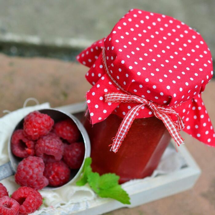 Eine süße Verführung die frischen Himbeeren und die daraus gewonnen Himbeermarmelade.