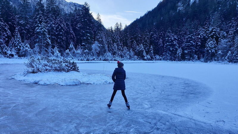 Gliding across the frozen mountain lake on ice skates.