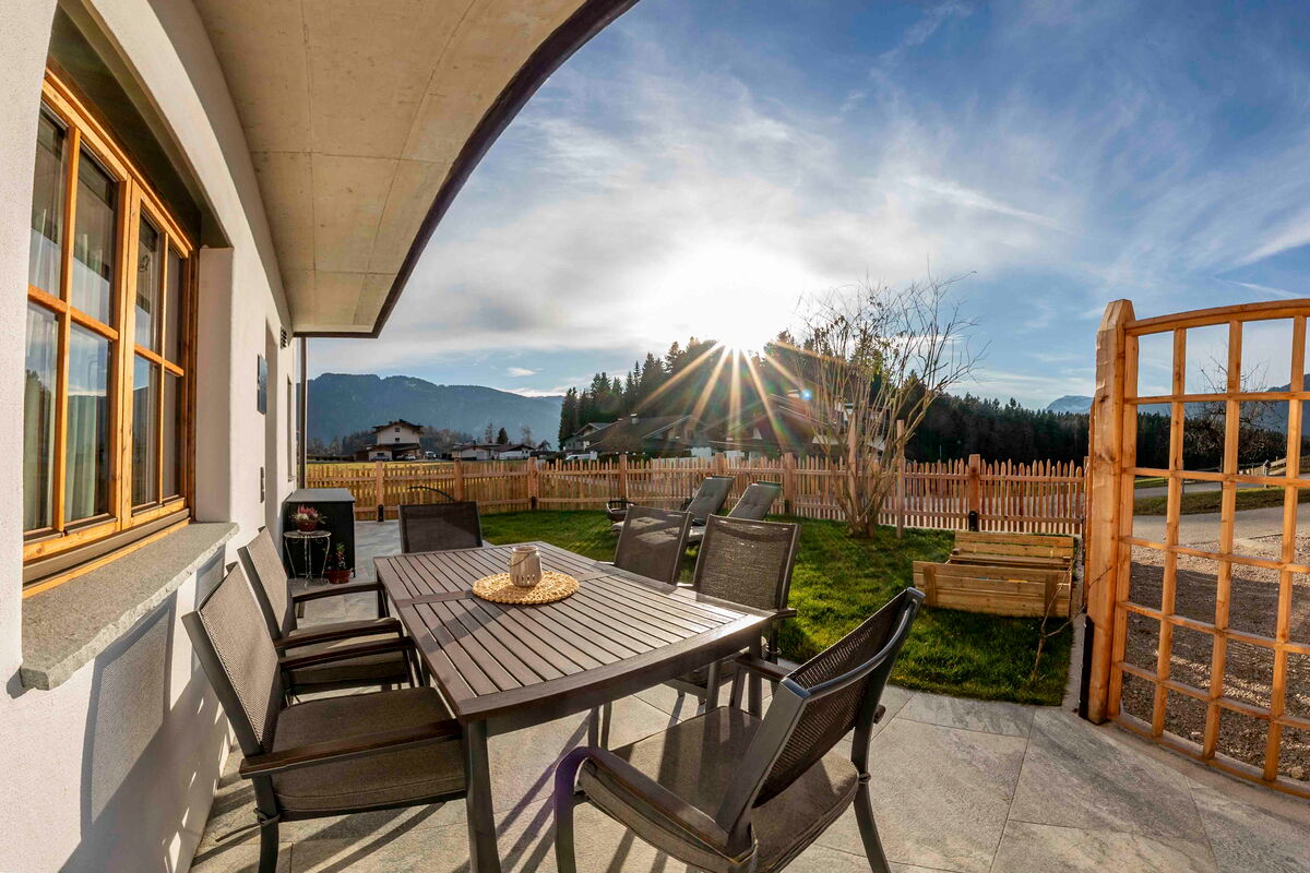 Terrasse am Zuahaus mit Tisch und Stühlen im Abendlicht, Ferienwohnung am Bauernhof im Alpbachtal