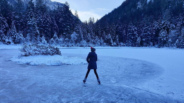 Über den zu gefrorenen Bergsee mit den Schlittschuhen gleiten.