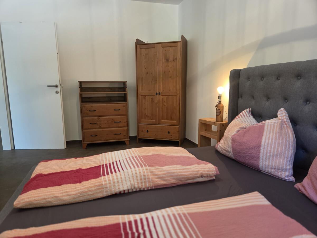 Schlafzimmer mit Doppelbett, Holzkommode und Kleiderschrank in der Pferdeheimat am Karwendel in Gnadenwald in Tirol