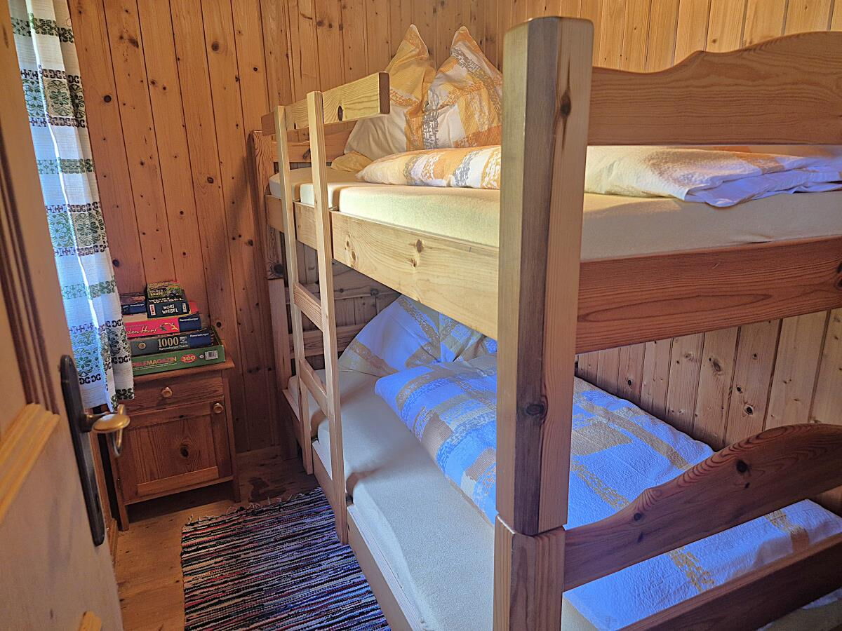 Stockbett mit Bücherregal in der Zarze Almhütte, Almhütte für Familien und Freunde in Matrei in Osttirol