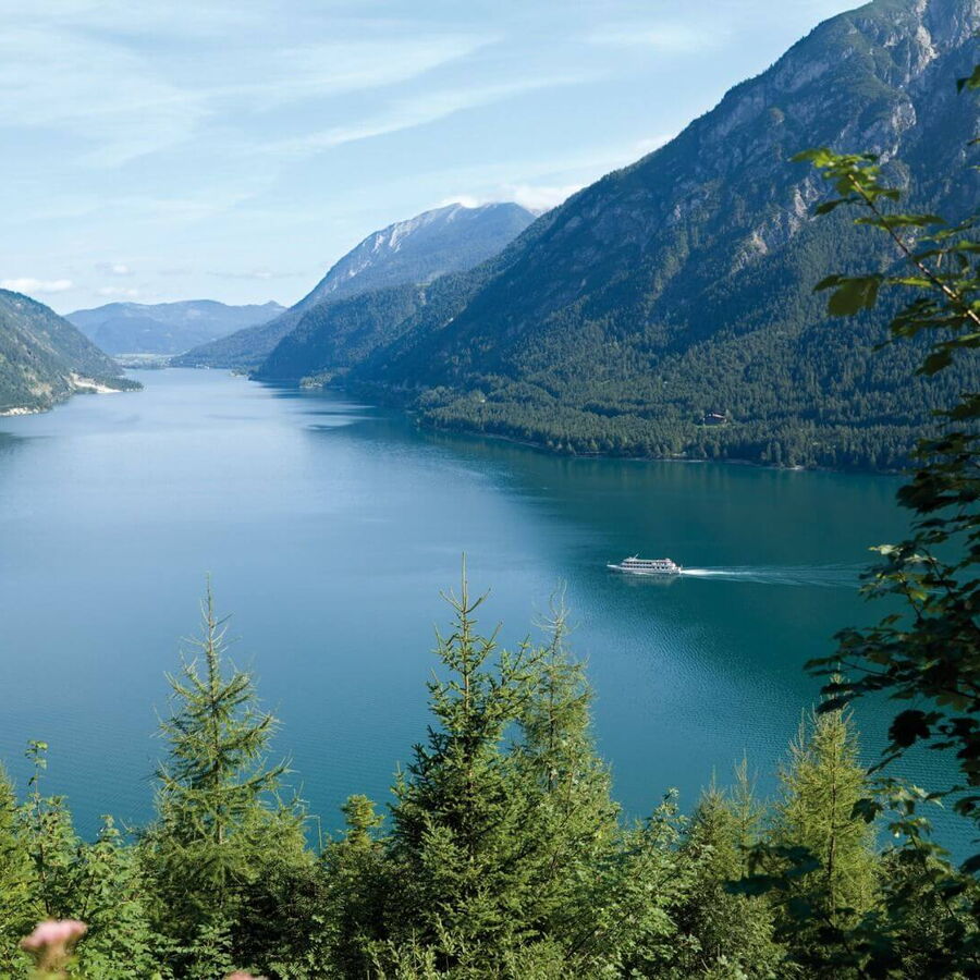 Den Achensee von oben bewundern, auf dem Wasser ist ein Dampfer zu sehen.