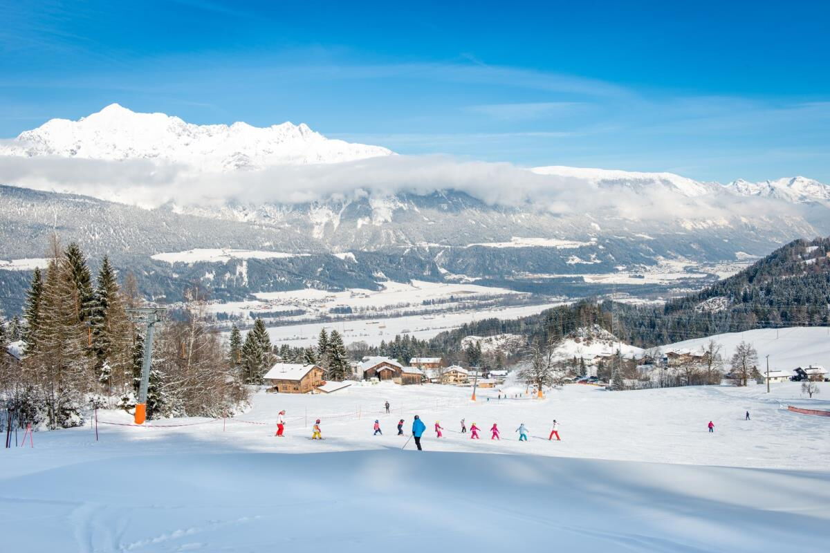 Der Hoferlift am Kolsassberg mit Skifahrern auf der verschneiten Piste vor dem Karwendel, fußläufig von der Ferienwohnung Sternenhimmel