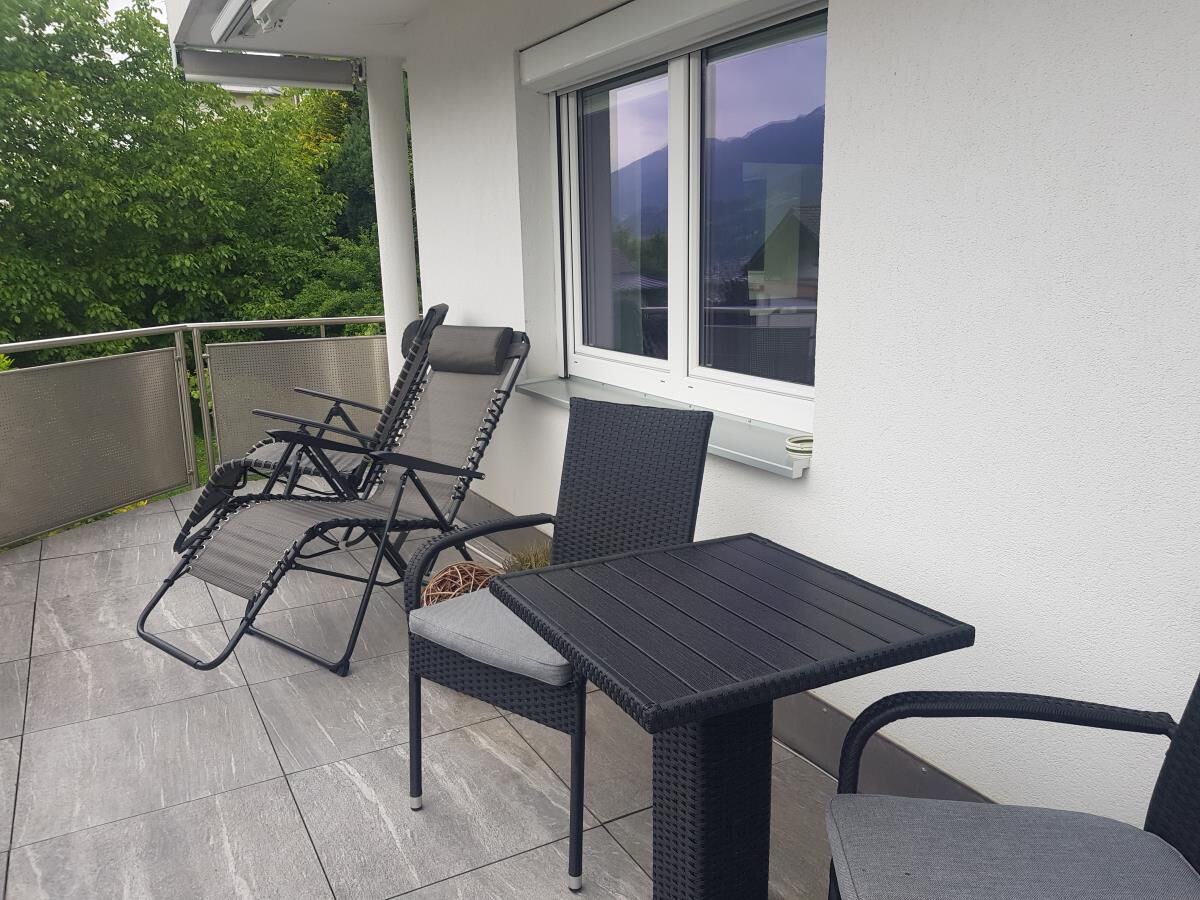 Große Terrasse der Ferienwohnung Sonnseitn Karwendel mit zwei Liegestühlen und Tisch vor dem Fenster